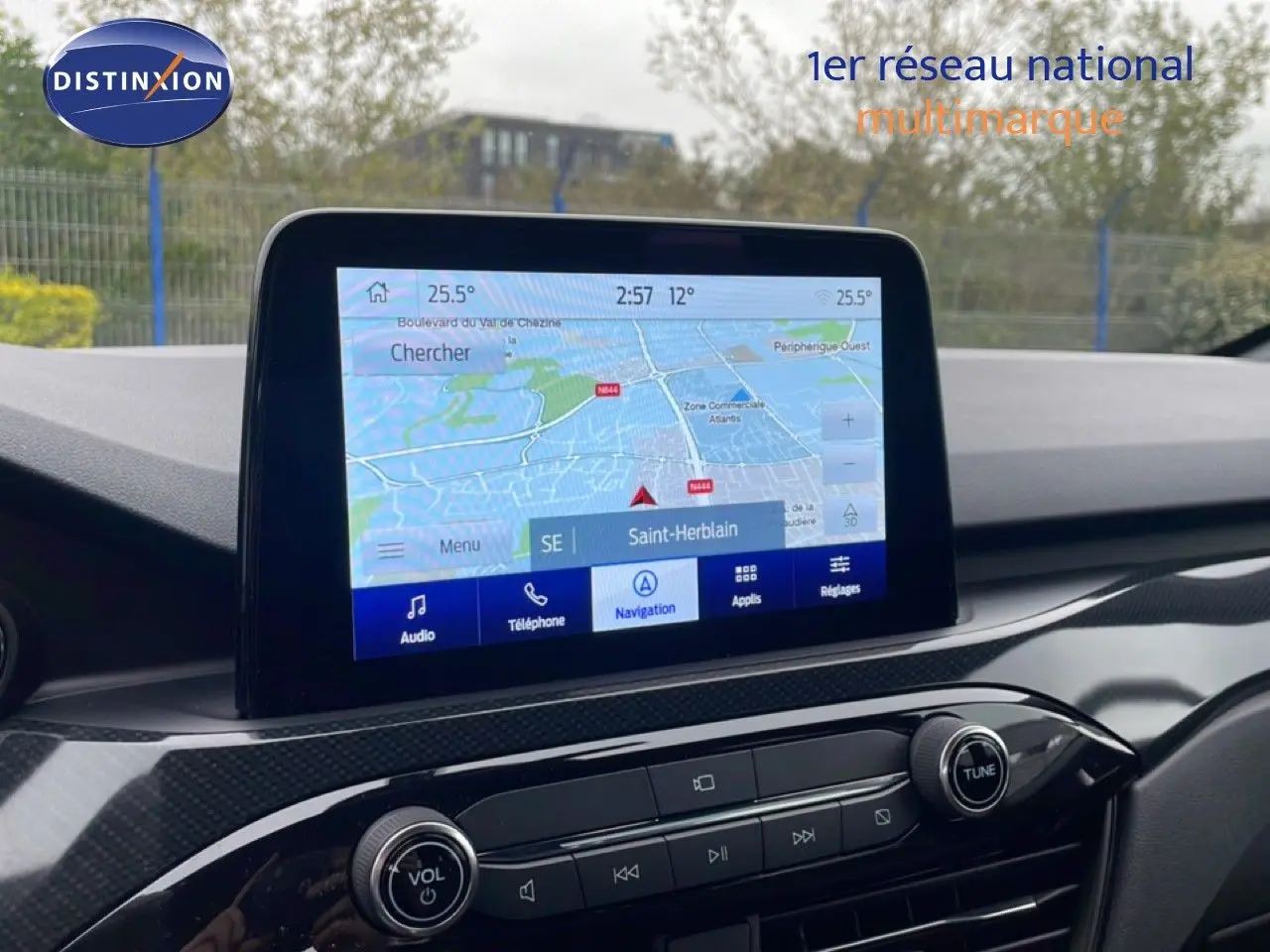 Vue rapprochée de l’écran tactile central du Ford Kuga 2024 bleu chrome, affichant la navigation GPS sur fond de tableau de bord noir.