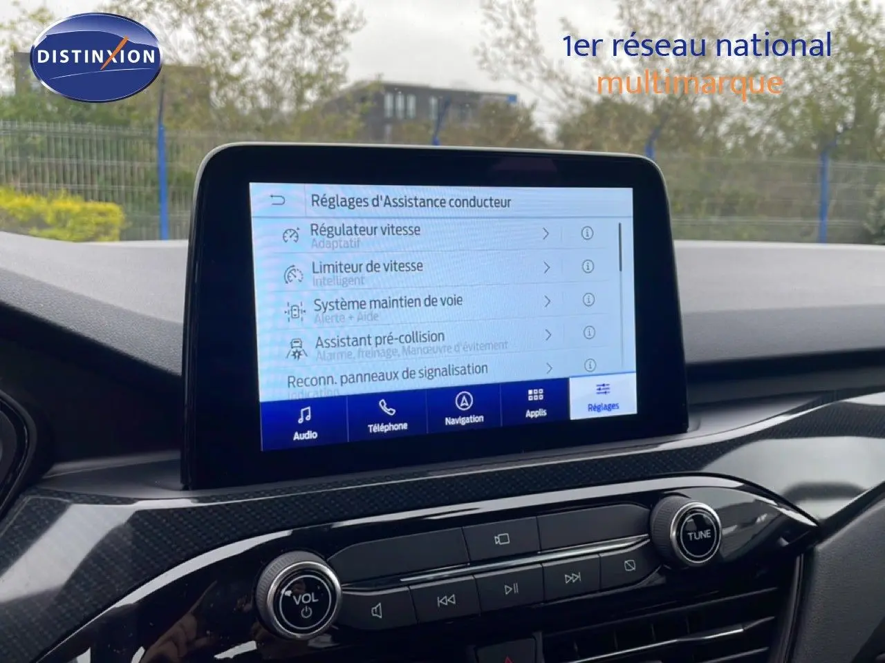 Vue intérieure du tableau de bord du Ford Kuga 2024 avec écran tactile affichant les réglages d'assistance conducteur.