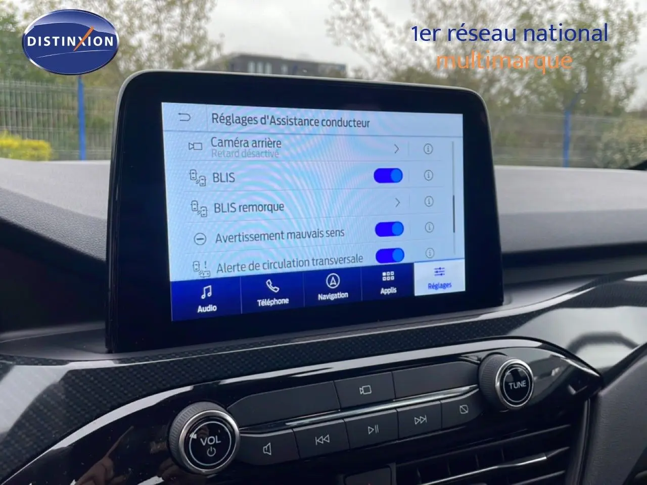 Vue rapprochée de l’écran central du Ford Kuga bleu chrome 2024 montrant les réglages d’assistance conducteur.