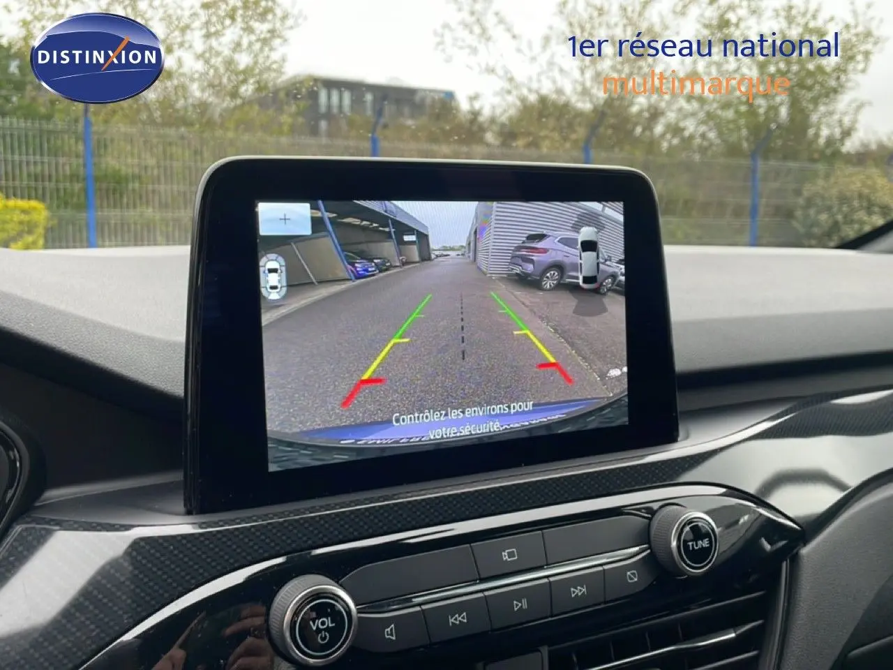 Vue intérieure du tableau de bord du Ford Kuga bleu chrome métal 2024, avec écran de caméra de recul affiché.