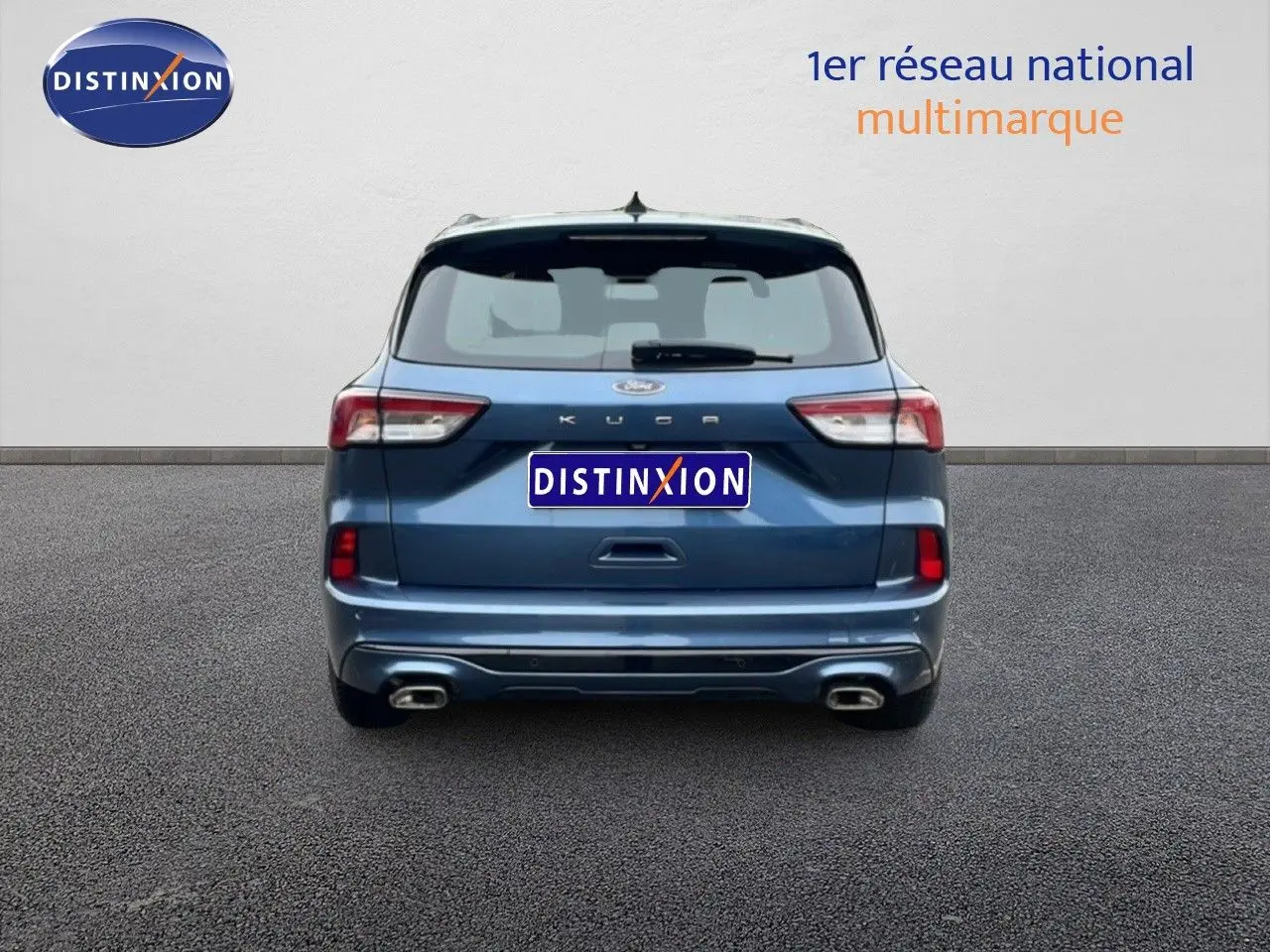 Vue arrière d'un Ford Kuga 2024 bleu chrome métal avec double sortie d'échappement et logo ST-Line visible.