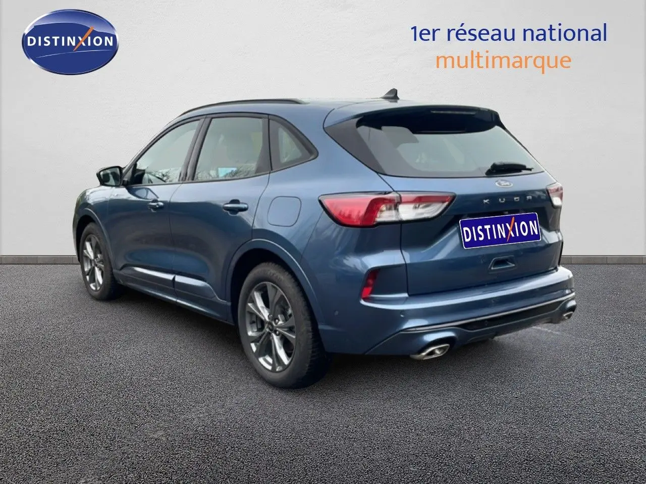 Vue 3/4 arrière droite d’un Ford Kuga bleu chrome métal 2024 avec double sortie d’échappement et jantes alliage.