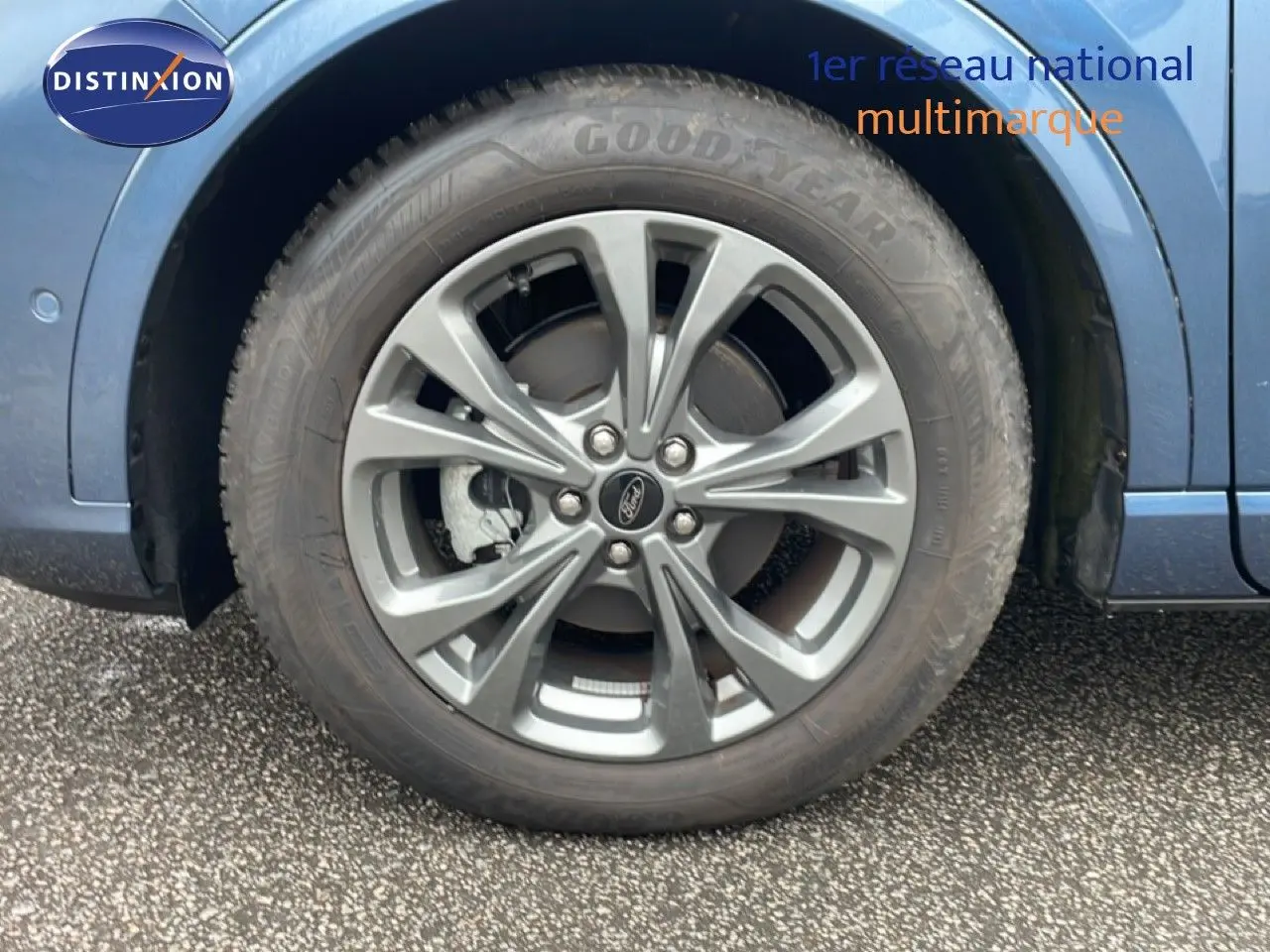 Gros plan sur la roue avant droite du Ford Kuga bleu chrome métal, mettant en valeur la jante alliage et le pneu Goodyear.