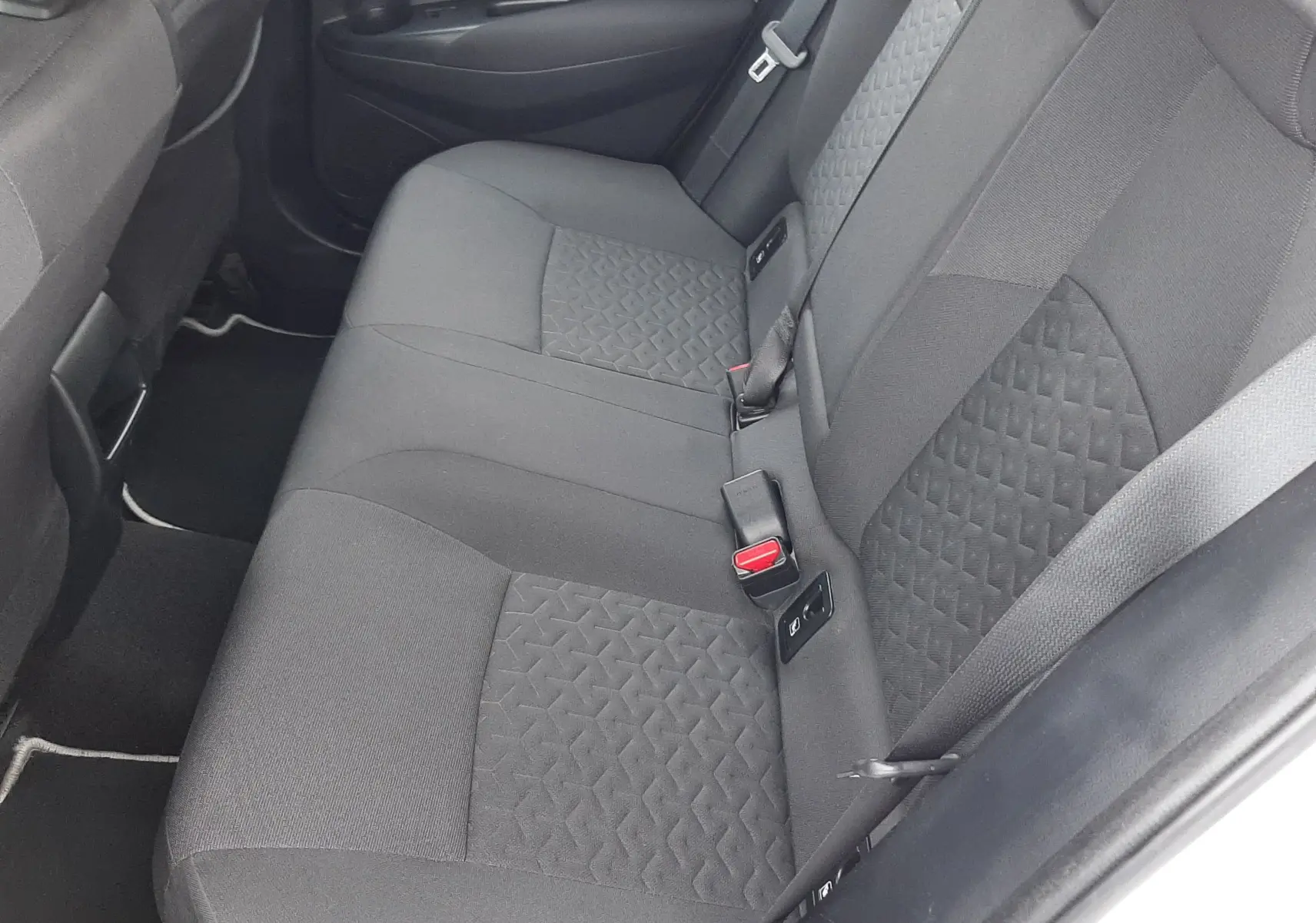 Vue intérieure côté droit des sièges arrière en tissu gris de la Toyota Corolla 122 CH Dynamic blanche de 2022.