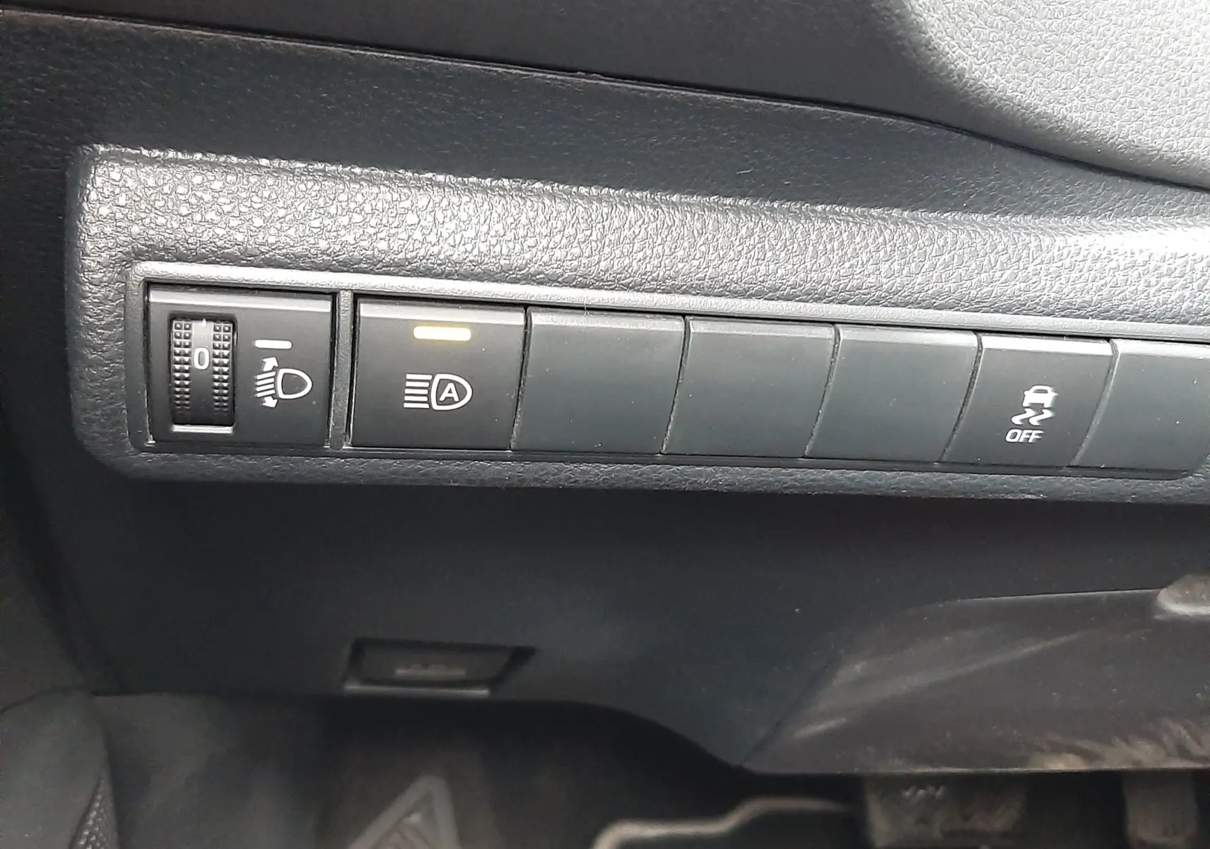 Gros plan sur les commandes noires du tableau de bord côté conducteur de la Toyota Corolla blanche 2022 hybride.