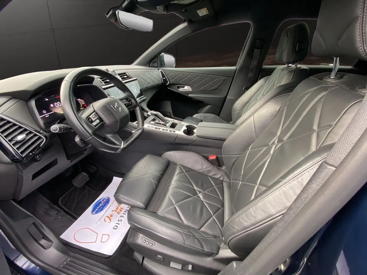 Vue intérieure côté conducteur du DS7 2024 en sellerie cuir noir électrique avec tableau de bord et console moderne.