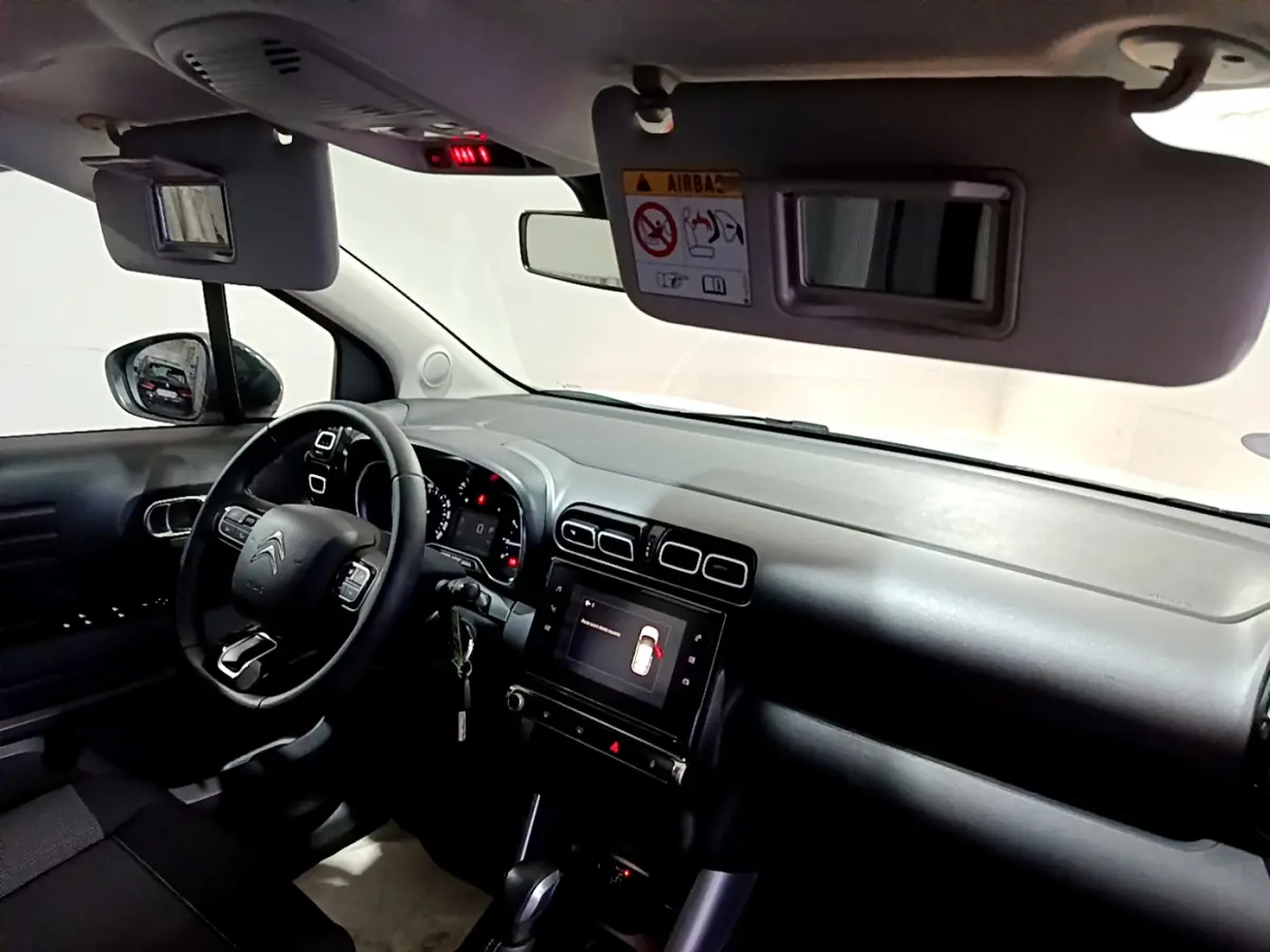 Vue intérieure côté conducteur du tableau de bord noir du Citroën C3 Aircross avec écran tactile et volant multifonctions.