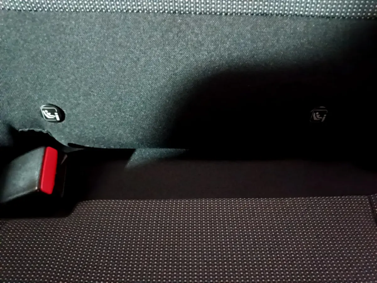 Gros plan sur la banquette arrière noire du Citroën C3 Aircross avec attaches Isofix visibles et boucle de ceinture rouge.