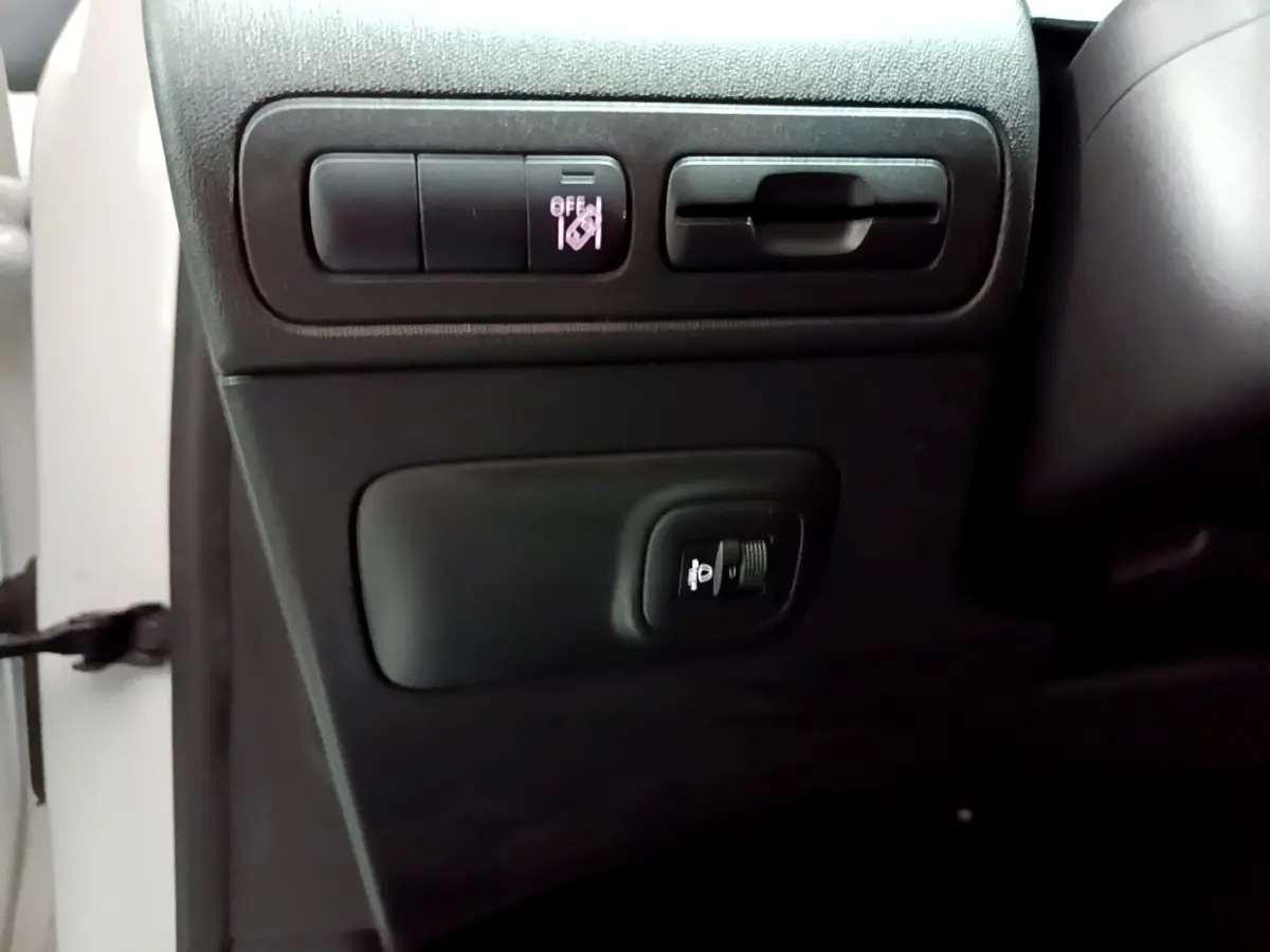 Détail des commandes d'éclairage sur la partie basse gauche du tableau de bord d'une Citroën C3 Aircross blanche 2019.