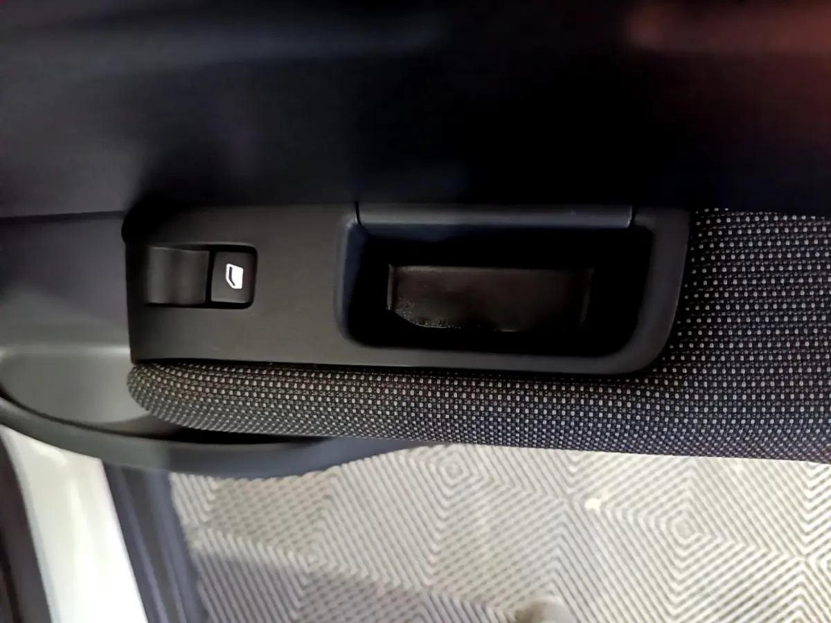 Poignée intérieure et bouton de lève-vitre sur la portière côté droit d’un Citroën C3 Aircross blanc.