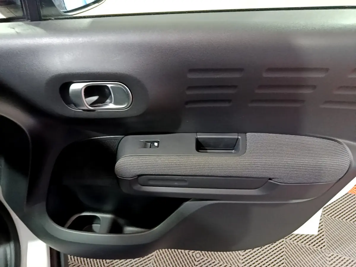 Gros plan sur la porte intérieure côté gauche noire et tissu gris du Citroën C3 Aircross blanc 2019.