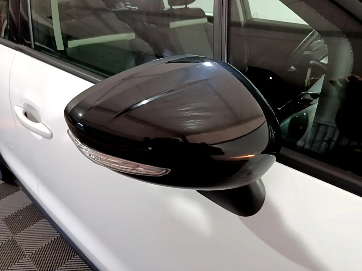 Rétroviseur noir avec clignotant intégré côté gauche sur porte blanche d'une Citroën C3 Aircross 2019.