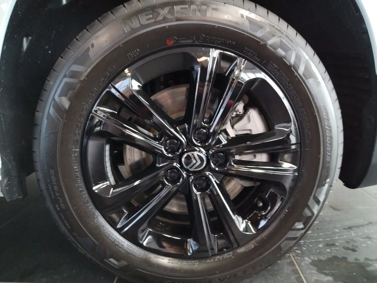 Gros plan sur la jante alu noir Starlit avec logo Citroën au centre du CITROEN BERLINGO blanc 2025.