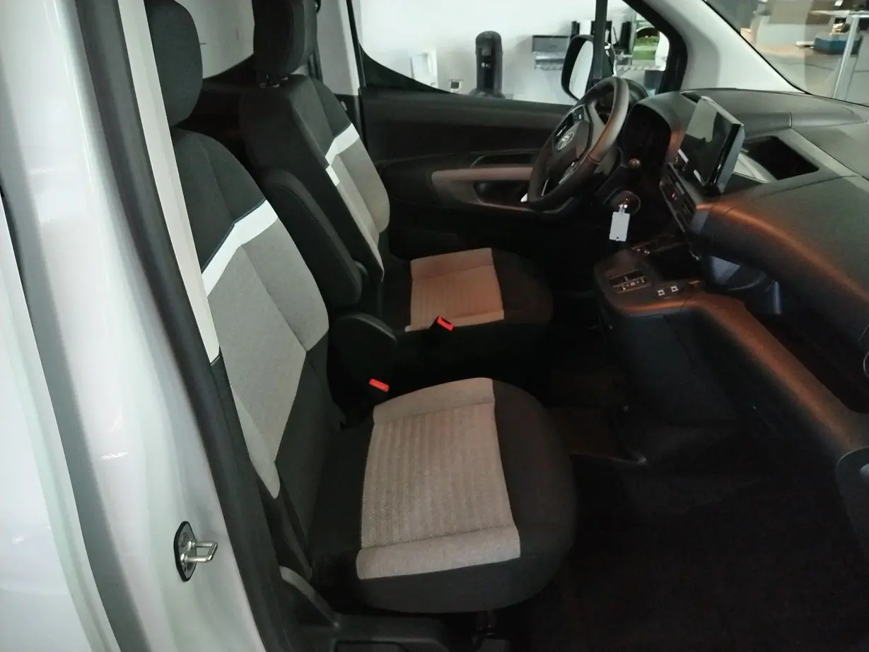 Vue intérieure côté gauche du Citroën Berlingo blanc 2025, montrant les sièges avant bi-ton et le tableau de bord moderne.