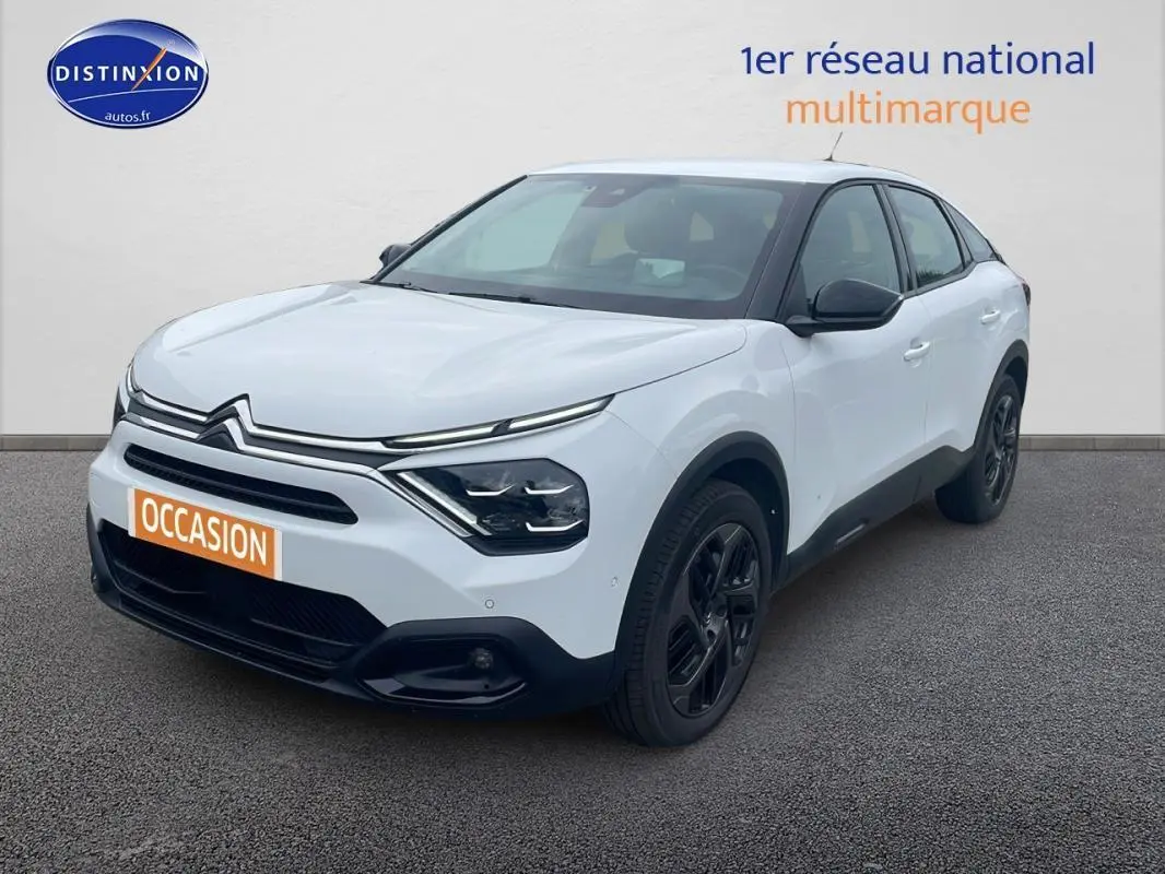 Citroën C4 blanc vue 3/4 avant droit avec jantes alliage noires et calandre distinctive moderne.