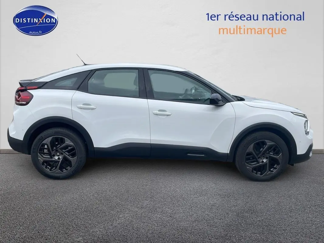 Profil côté gauche d'une Citroën C4 blanche de 2022 avec jantes alliage noires et lignes noires contrastantes.