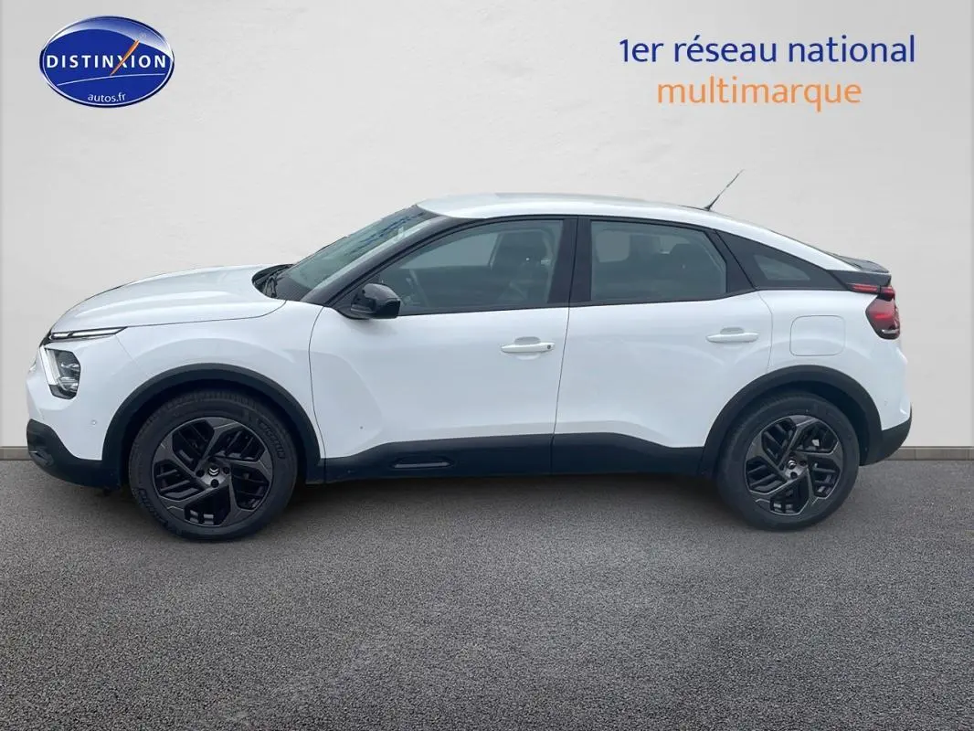 Profil côté gauche d'une Citroën C4 blanche 2022 avec jantes alliage noires et lignes modernes distinctives.