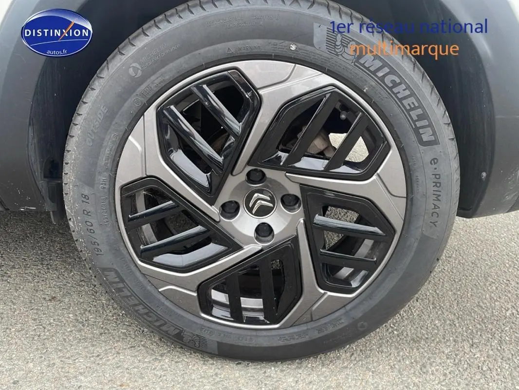 Gros plan sur la jante alliage 18 pouces noire et grise d'une Citroën C4 blanche Diesel 2022.