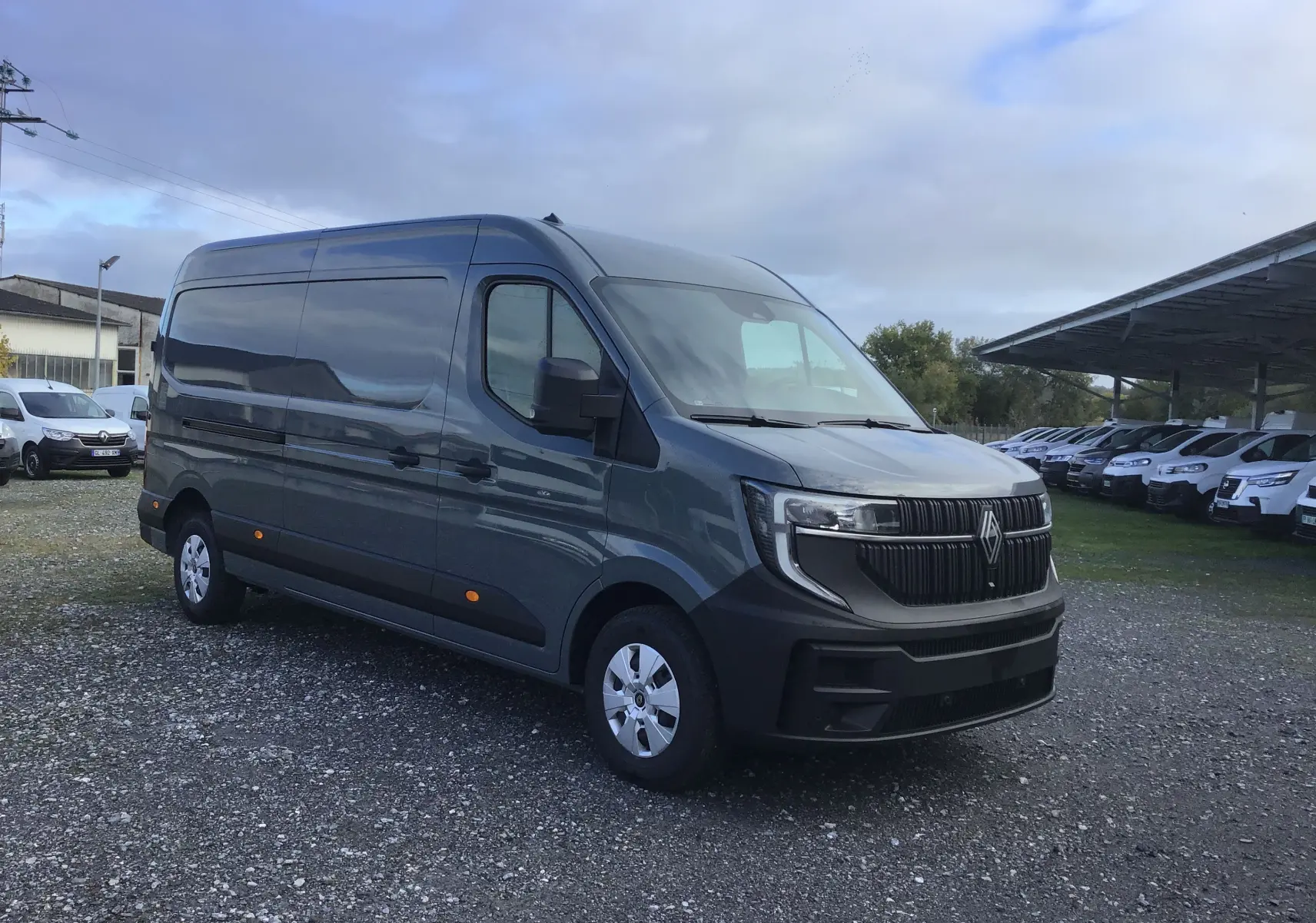 Vue 3/4 avant droit du Renault Master gris urbain 2025 avec calandre noire distinctive et feux LED.