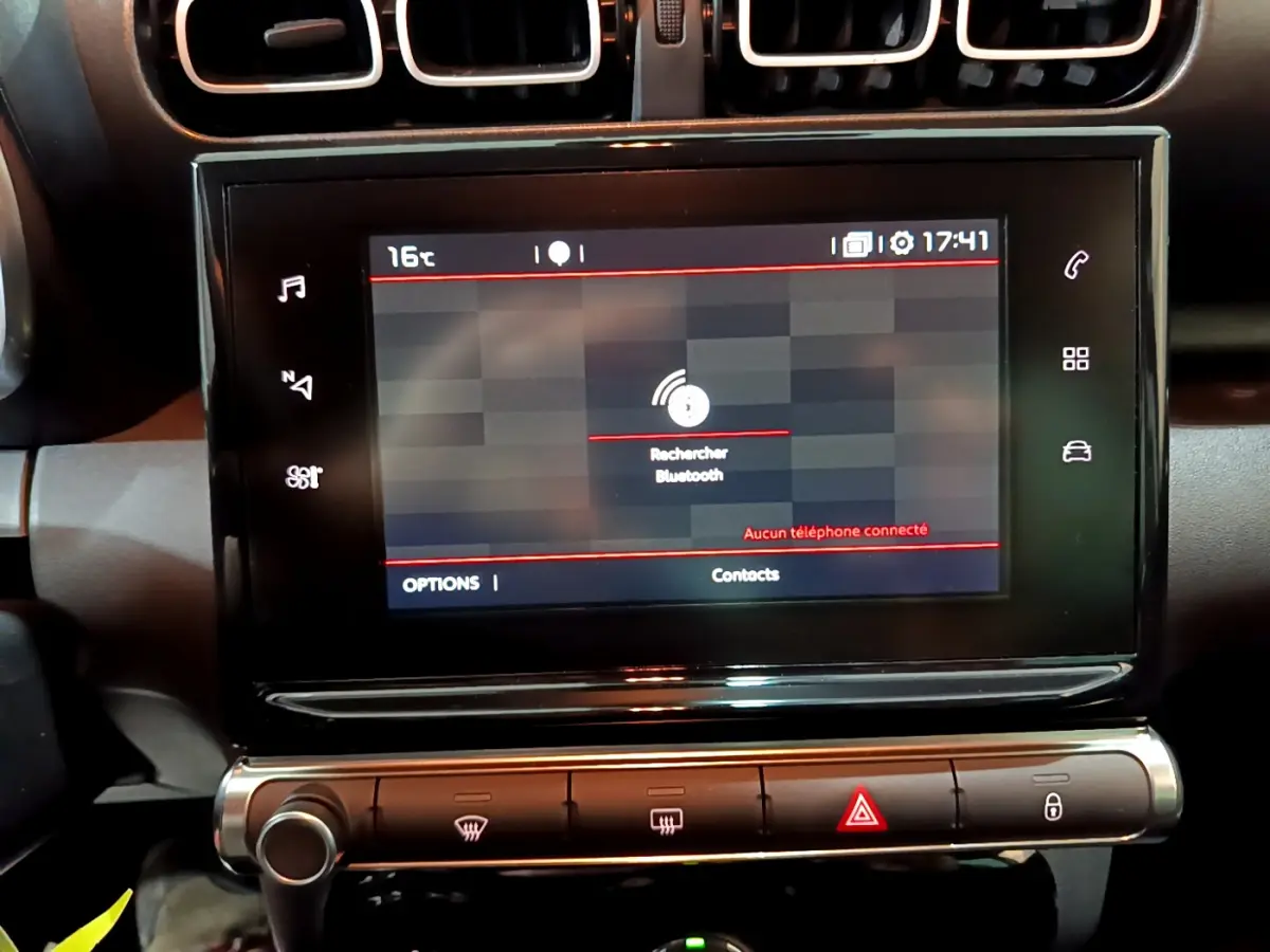 Gros plan sur l'écran tactile central noir du tableau de bord du Citroën C3 Aircross avec commandes climatisation en dessous.