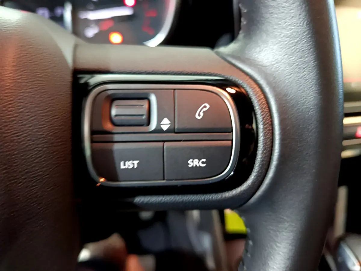 Gros plan sur les commandes gauche du volant cuir noir du Citroën C3 Aircross 2019, boutons appel et audio visibles.