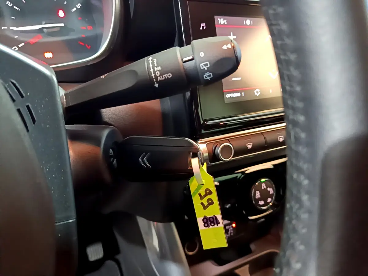 Gros plan sur la manette d'essuie-glace et le tableau de bord tactile noir du Citroën C3 Aircross PureTech 110 Shine.