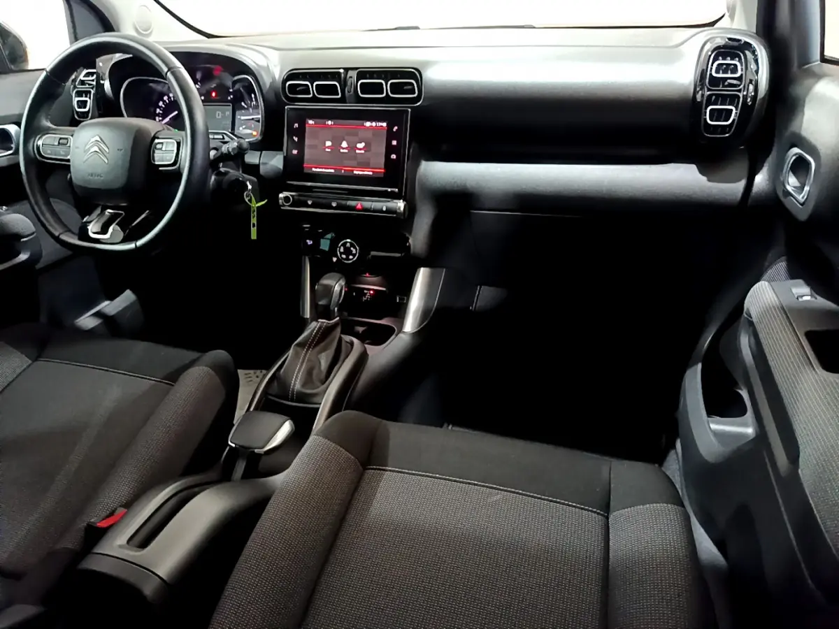 Vue intérieure avant du Citroën C3 Aircross noir, montrant le tableau de bord avec écran tactile et volant multifonctions.