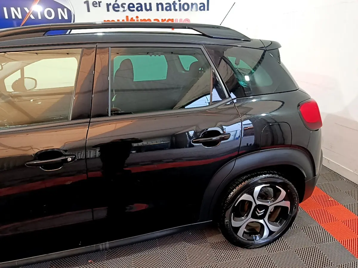 Vue latérale côté gauche d'un Citroën C3 Aircross noir brillant, mettant en valeur les jantes originales et les poignées de porte.