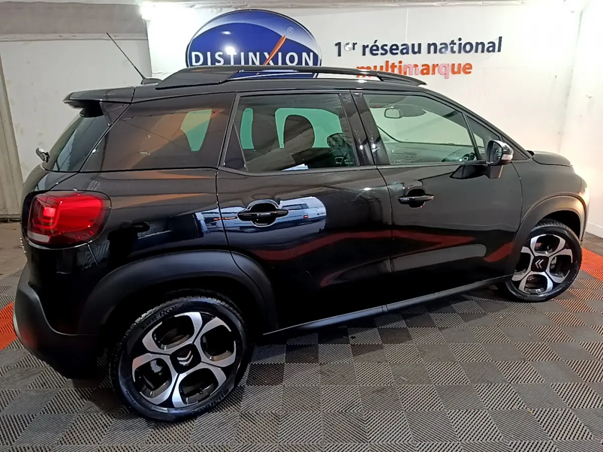 Vue de profil côté gauche d'un Citroën C3 Aircross noir 2019 avec barres de toit et jantes distinctives.