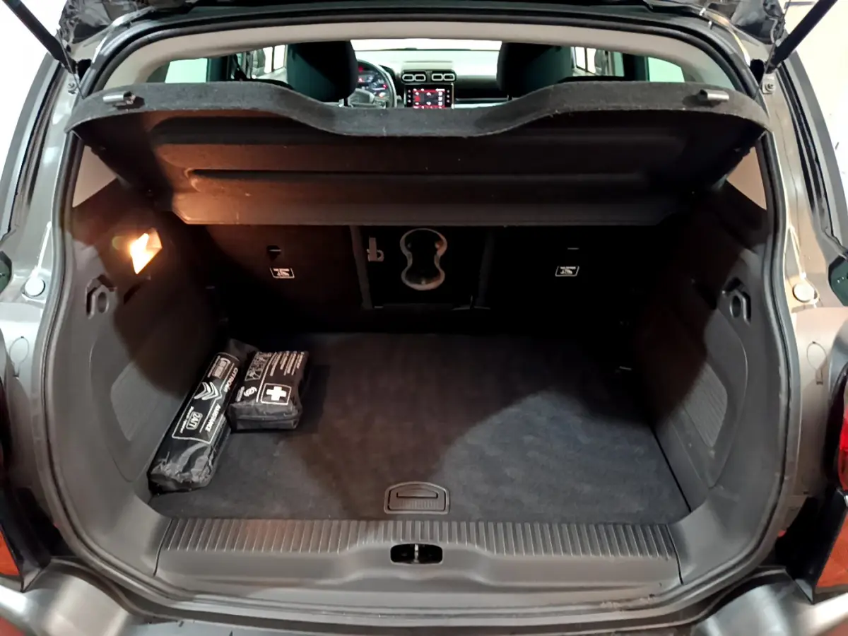 Coffre ouvert d'une Citroën C3 Aircross noir, vue arrière montrant l'espace de chargement et la tablette de séparation.