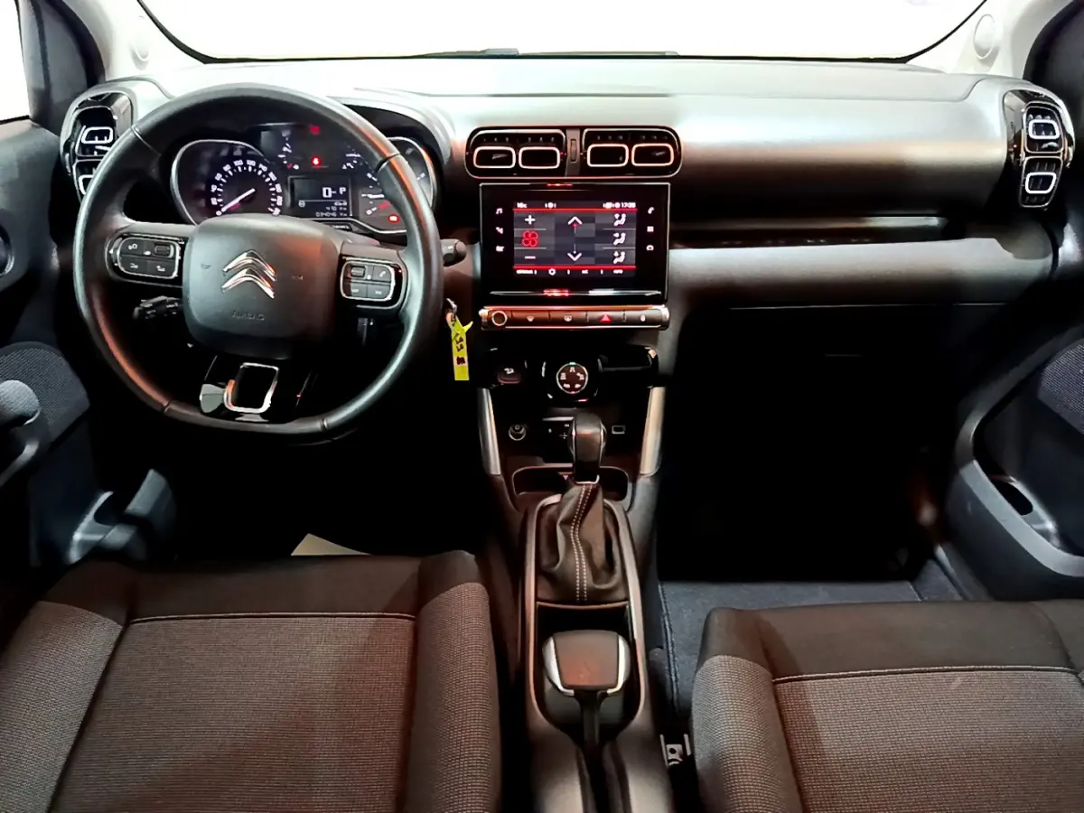Intérieur noir du Citroën C3 Aircross 2019 vu de face, tableau de bord avec écran tactile central et volant multifonctions cuir.