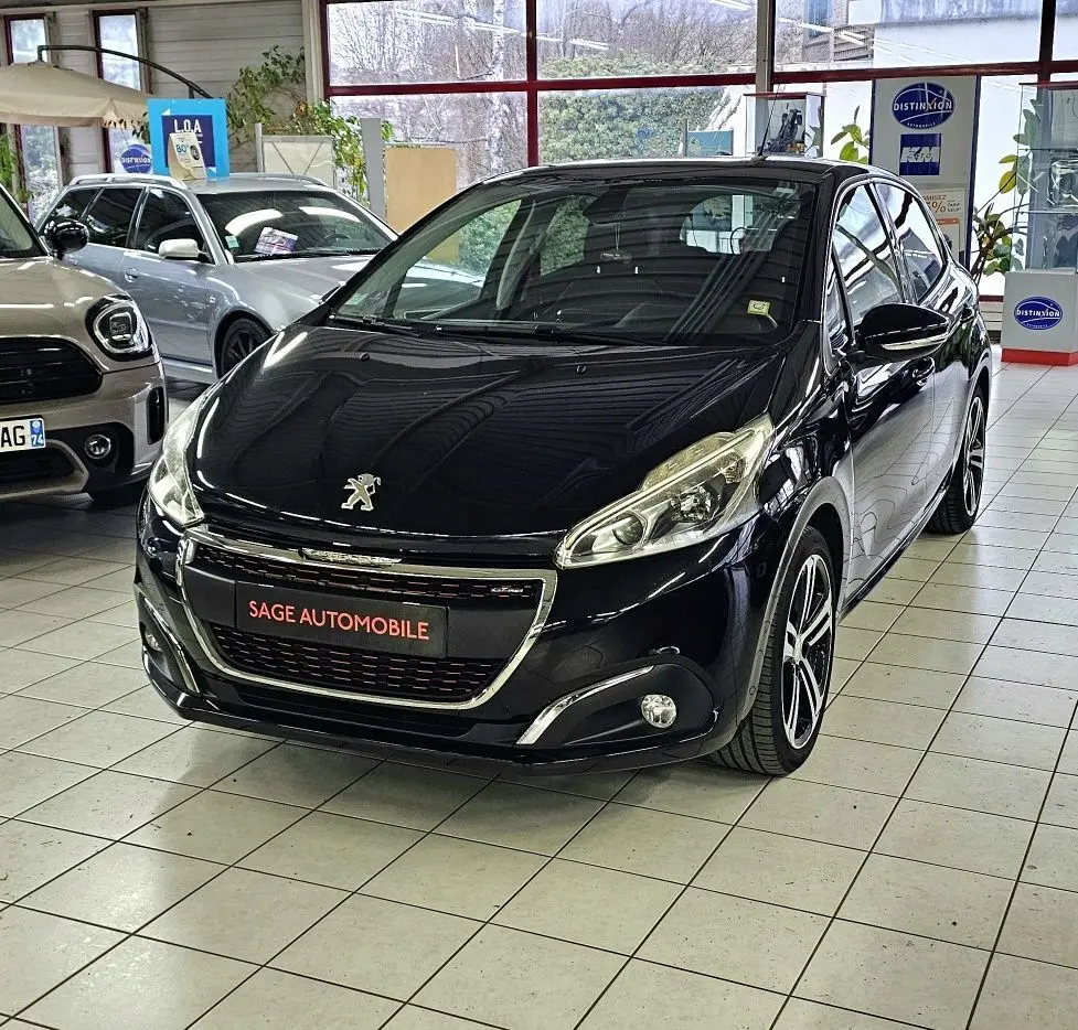 Peugeot 208 GT-LINE noir vue 3/4 avant droit en showroom avec jantes alliage et phares halogènes.