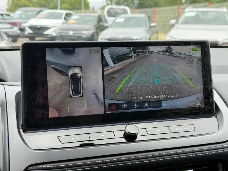 Écran tactile intérieur montrant la caméra 360° et vue arrière du Nissan Qashqai gris Argile, tableau de bord moderne.