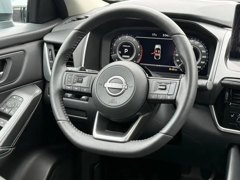 Vue rapprochée du volant cuir multifonction noir du Nissan Qashqai 2025 avec tableau de bord numérique affichant la vitesse et la température.