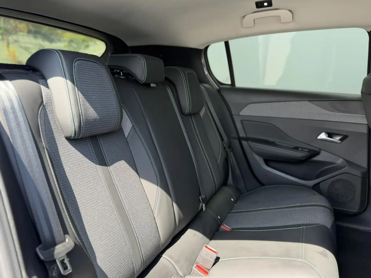 Vue latérale droite des sièges arrière en tissu et cuir noir de la Peugeot 308 1.5 BlueHDI 130 Allure 2025.