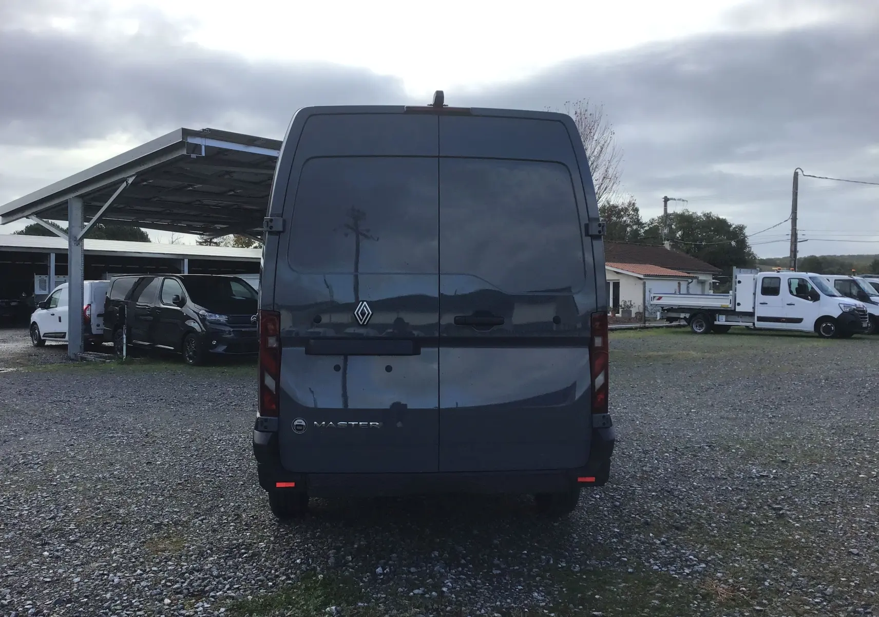 Vue arrière d’un Renault Master gris urbain 2025, avec portes arrière fermées et logo visible au centre.