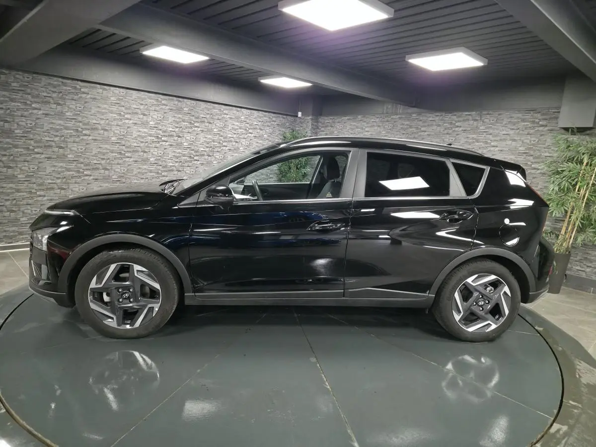 Profil côté gauche d'un Hyundai Bayon noir 2025 avec jantes alliage 17 pouces et vitres surteintées.