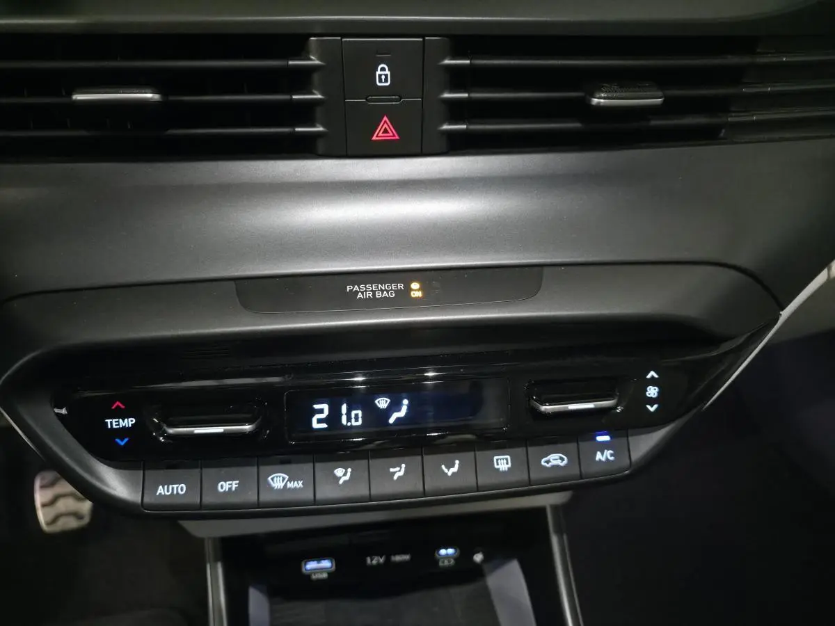 Vue rapprochée du panneau de climatisation automatique noir du Hyundai BAYON 2025 avec affichage digital à 21°C.