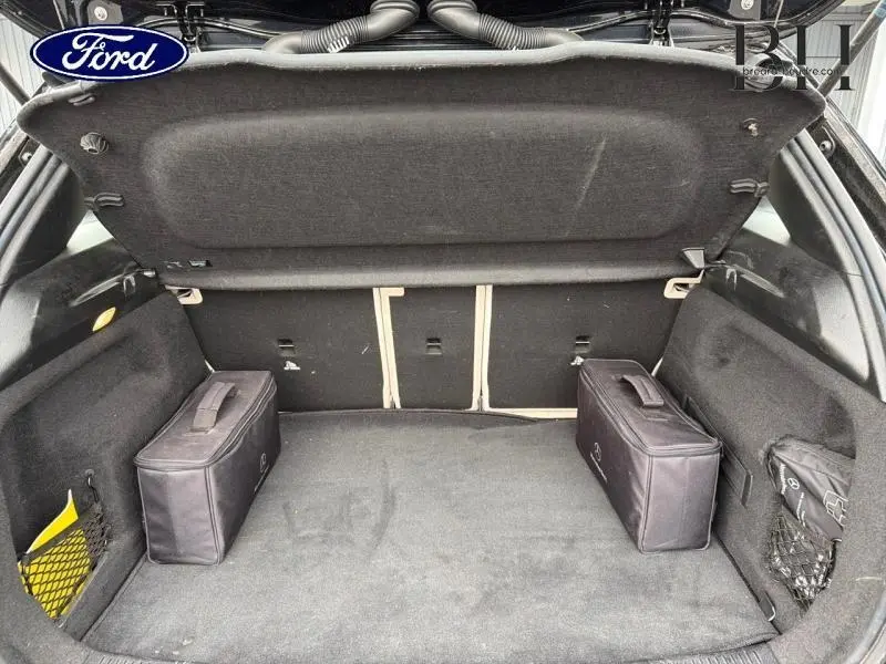 Coffre ouvert vu de l'arrière, intérieur noir avec deux sacs de rangement, hayon EASY-PACK sur Mercedes Classe B 250e.