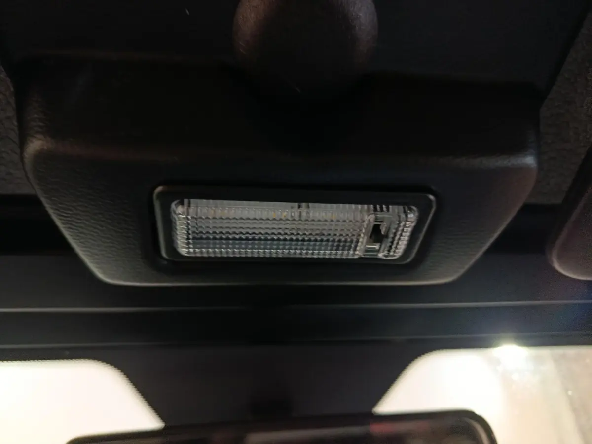 Gros plan sur l'éclairage intérieur au plafond d'une Aixam Ambition 0.5 City Pack gris clair, vue de l'habitacle.