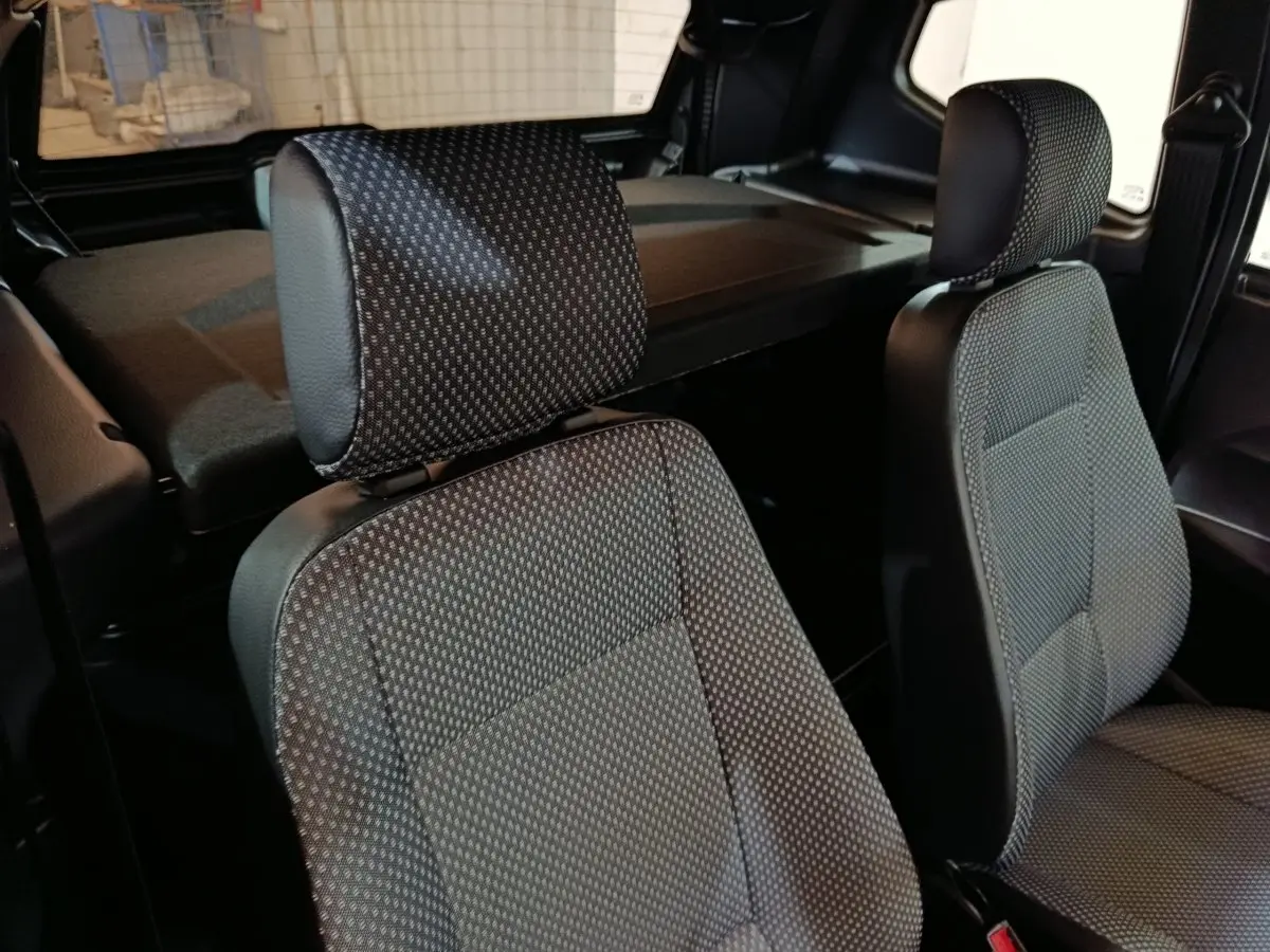 Gros plan sur les sièges avant en tissu gris d’une Aixam Ambition 0.5 City Pack 2026, intérieur sobre et fonctionnel.