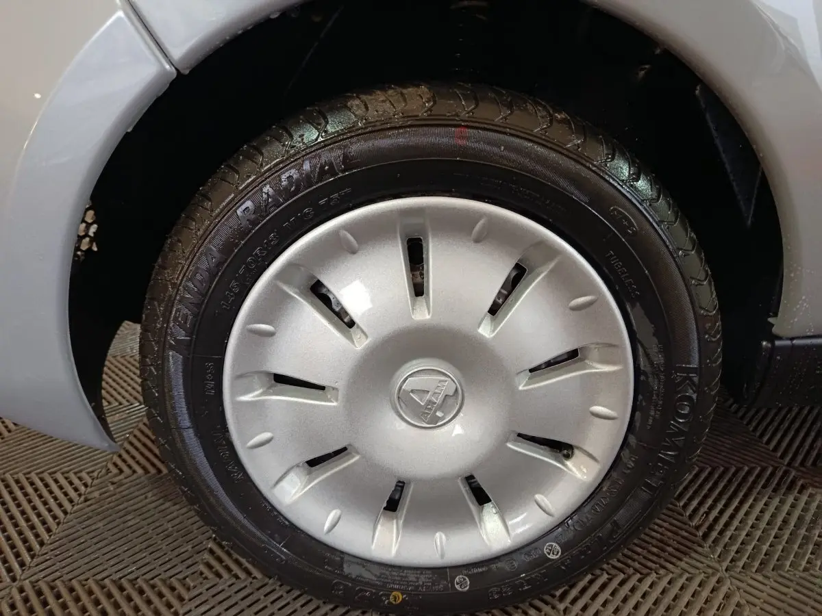 Gros plan sur la roue avant droite gris clair de l'AIXAM AMBITION 0.5 CITY PACK 2026 avec jante et logo central visible.