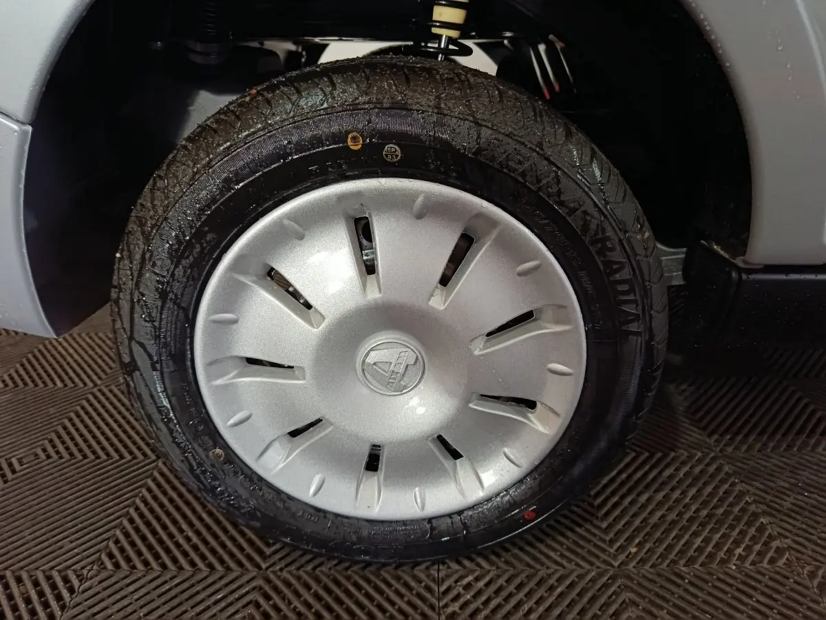 Gros plan sur la roue avant droite grise d’une Aixam Ambition 0.5 City Pack 2026 avec jante en plastique argenté.