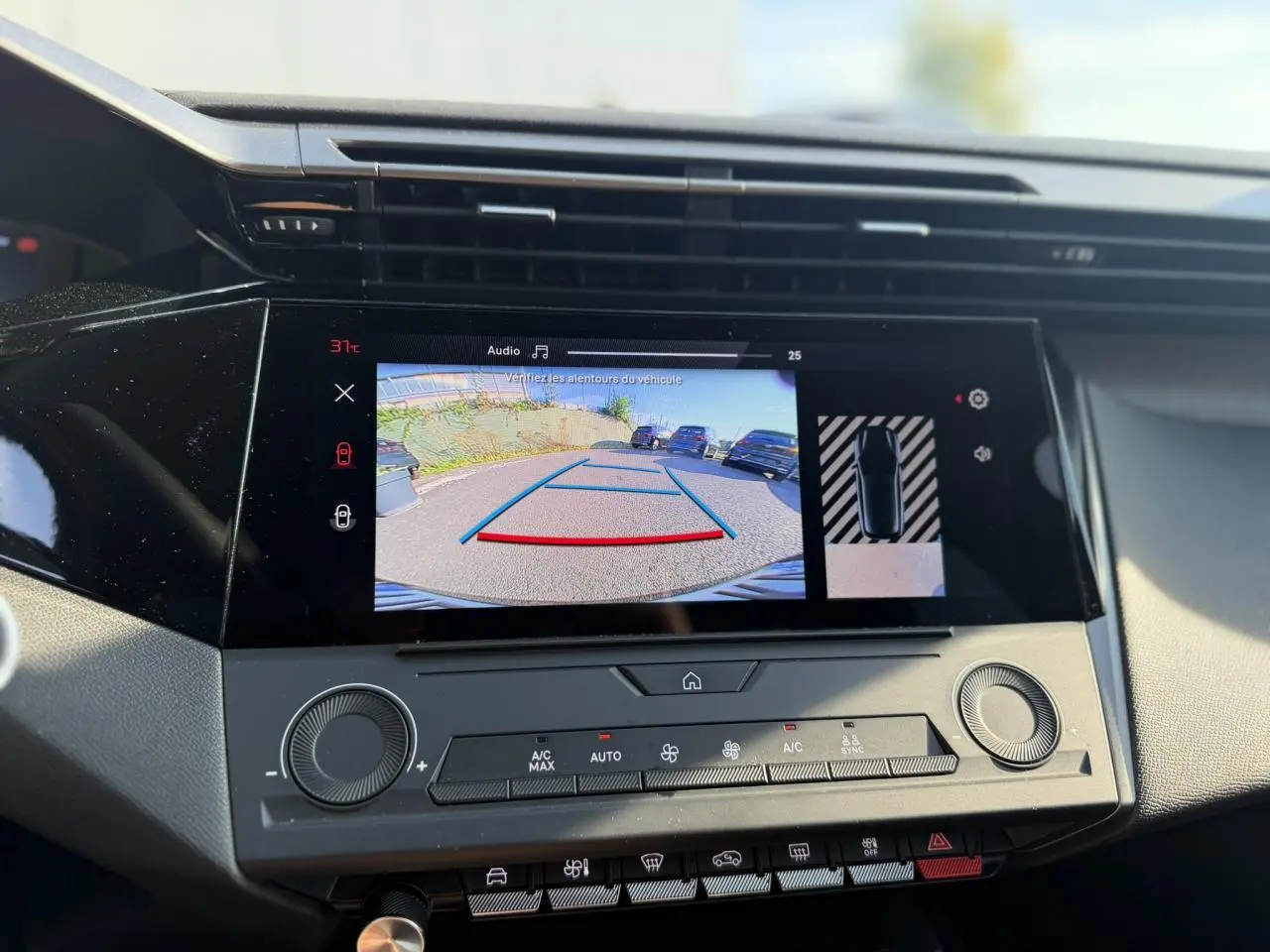 Vue rapprochée de l’écran tactile central affichant la caméra de recul dans l’habitacle d’une Peugeot 308 noire.