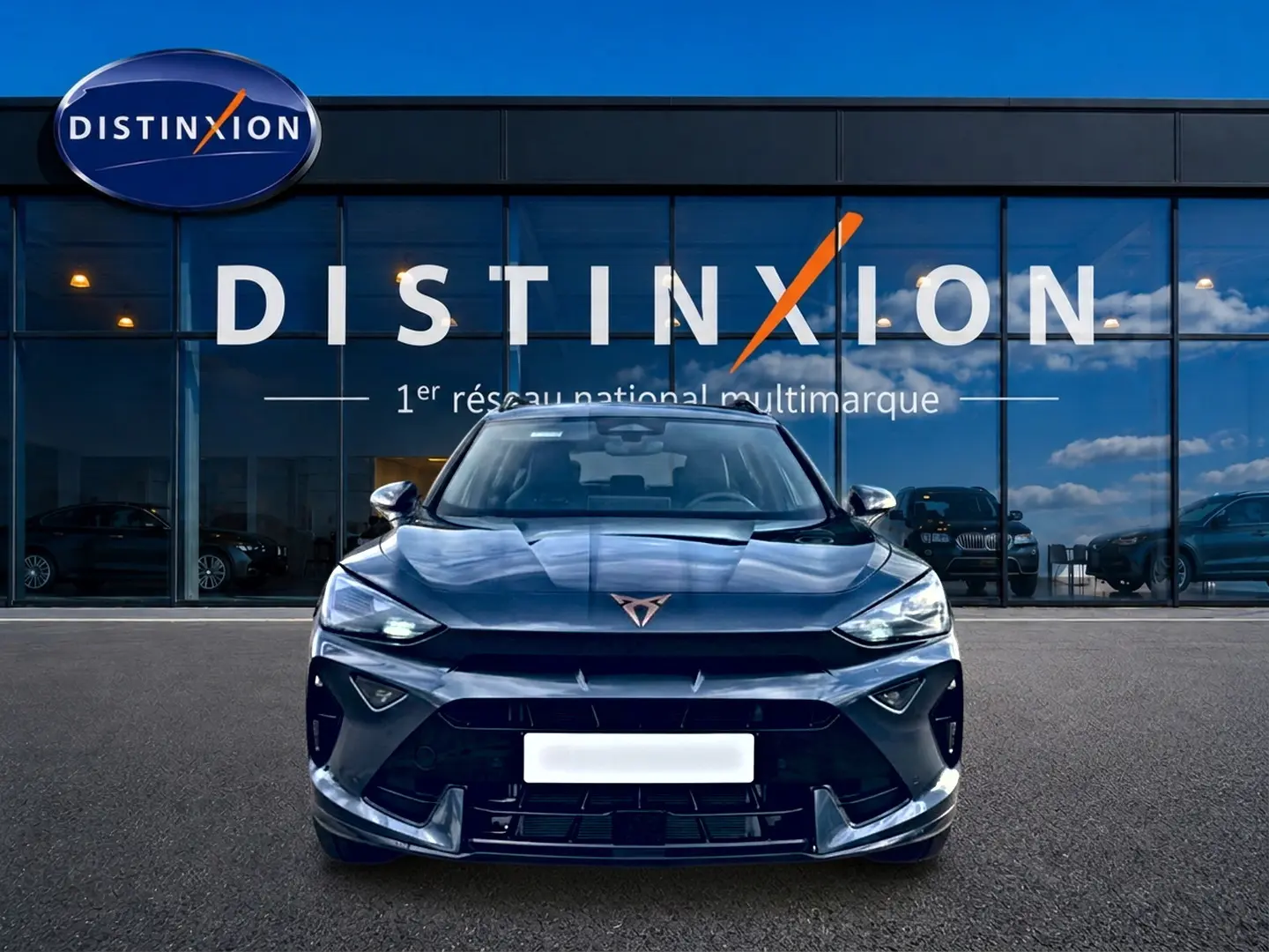 Vue frontale d'un CUPRA Formentor gris magnétique 2026 avec calandre sportive et logo distinctif sur fond de vitrine Distinxion.