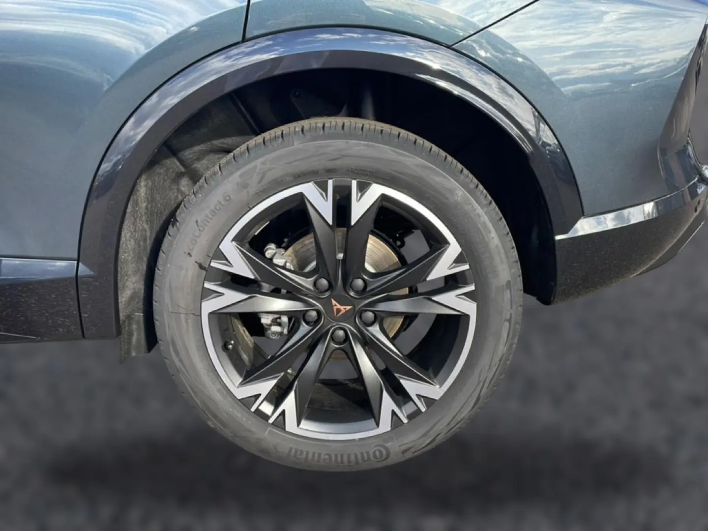 Gros plan sur la roue avant gauche du CUPRA Formentor gris magnétique avec jante noire et argentée au design distinctif.