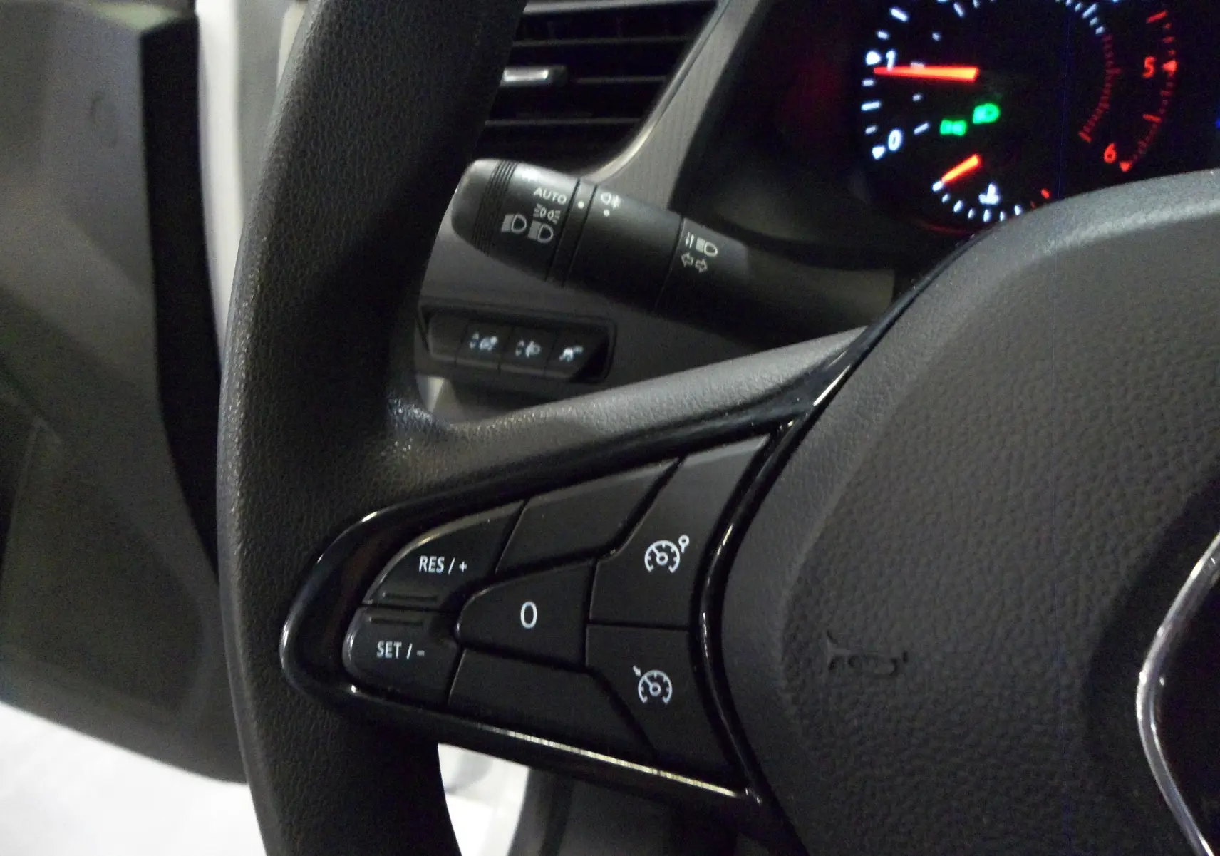 Gros plan sur le volant de Renault Kangoo 2022, montrant les commandes de régulateur de vitesse et le tableau de bord éclairé.