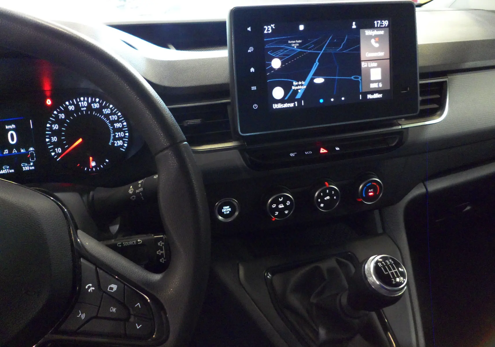 Intérieur du Renault Kangoo Van blanc, vue du tableau de bord avec écran tactile et levier de vitesse manuel visible.