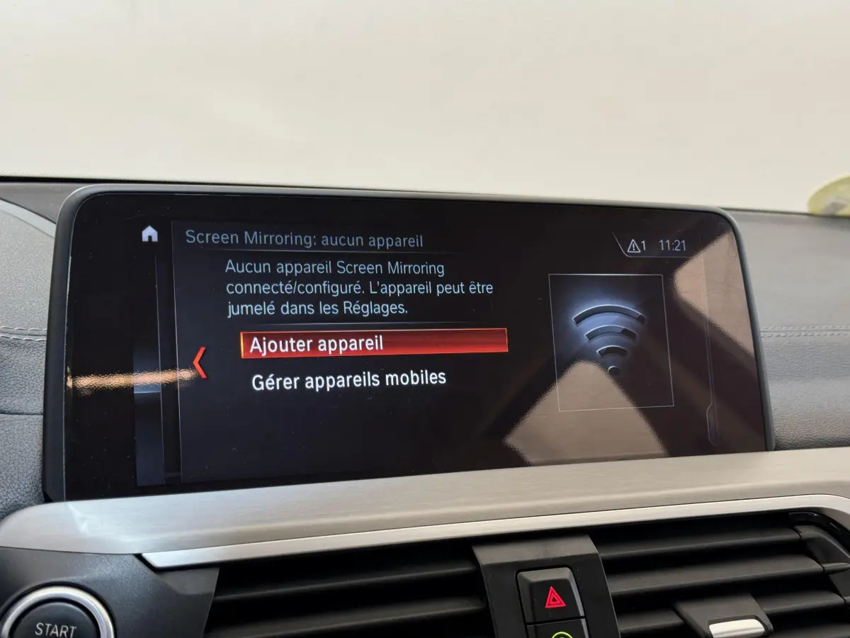 Vue intérieure du tableau de bord BMW X3 gris foncé 2018, écran tactile affichant menu de connexion mobile.
