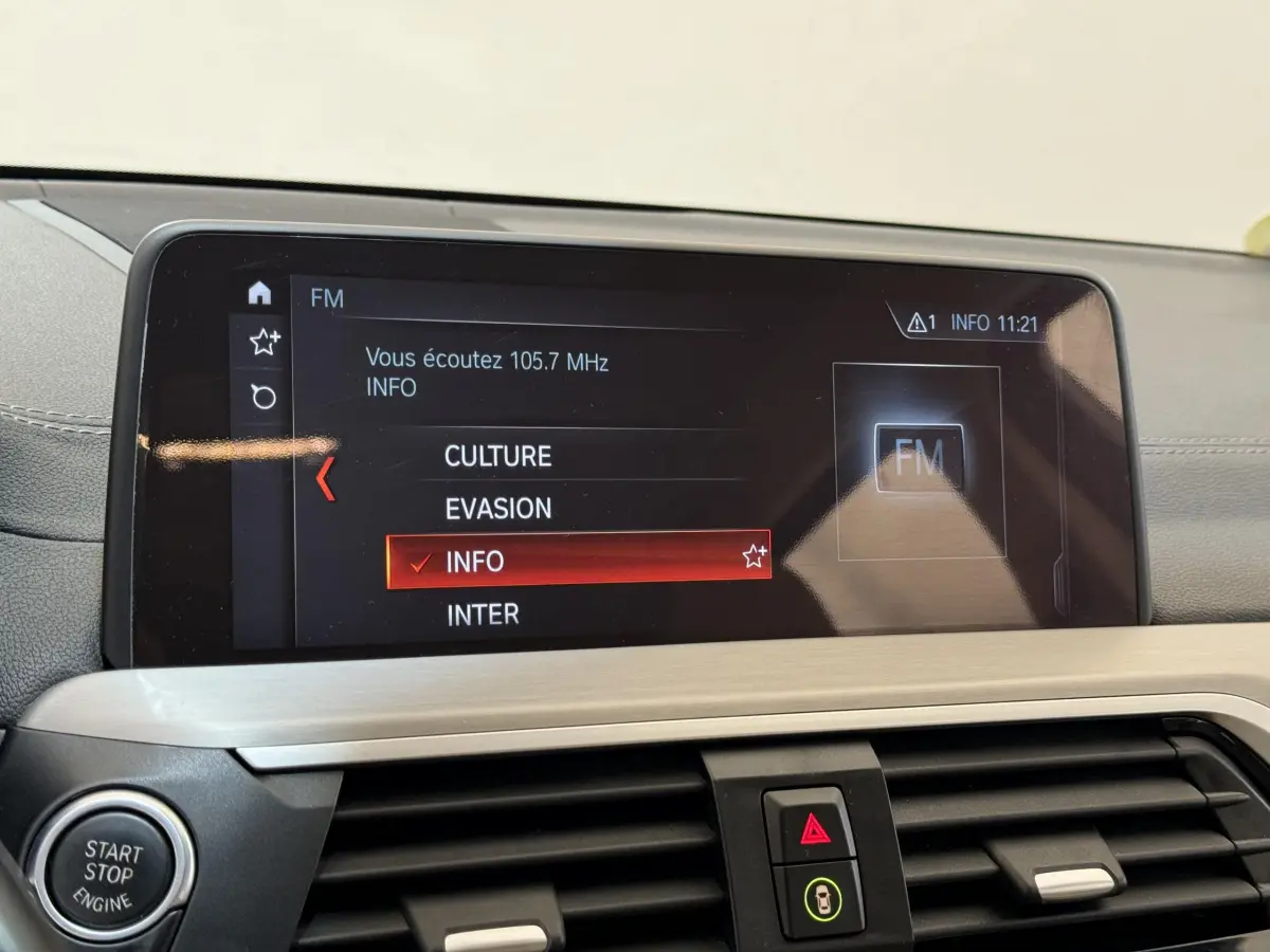 Écran tactile central affichant la radio FM dans l'habitacle gris clair d'une BMW X3 xDrive30d 2018